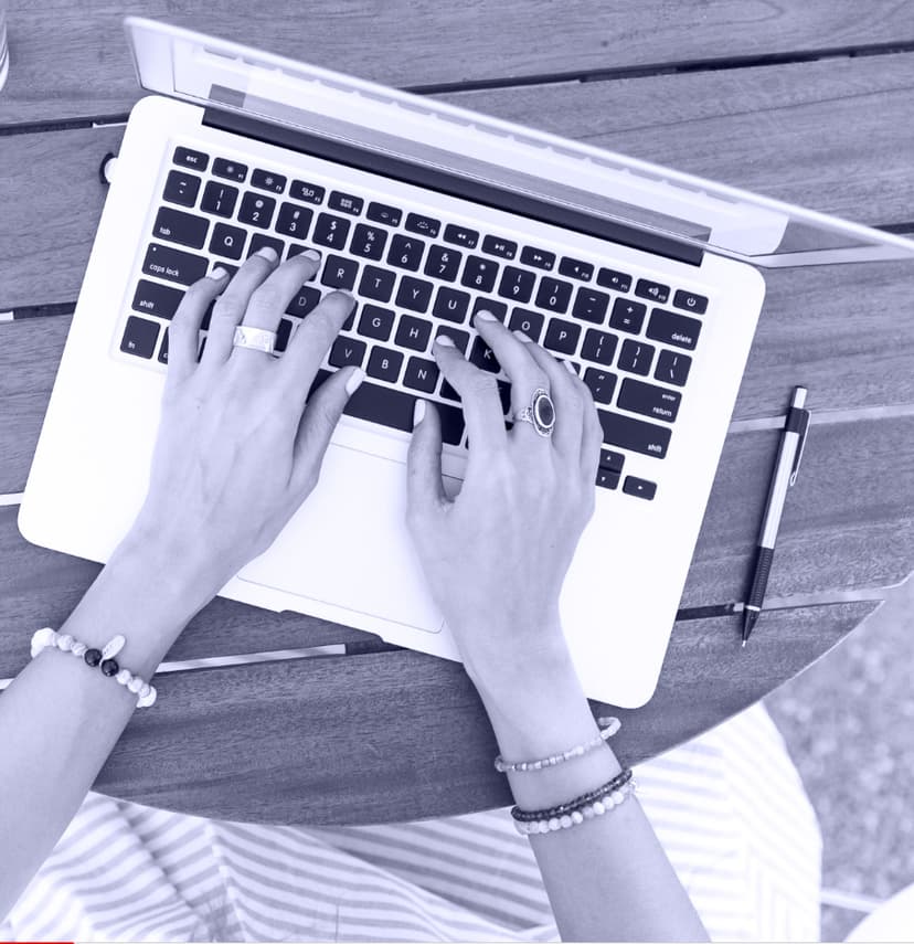 An image displaying a female typing an email on a macbook computer.